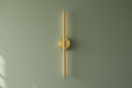 Brass stick lamp front view on sage wall